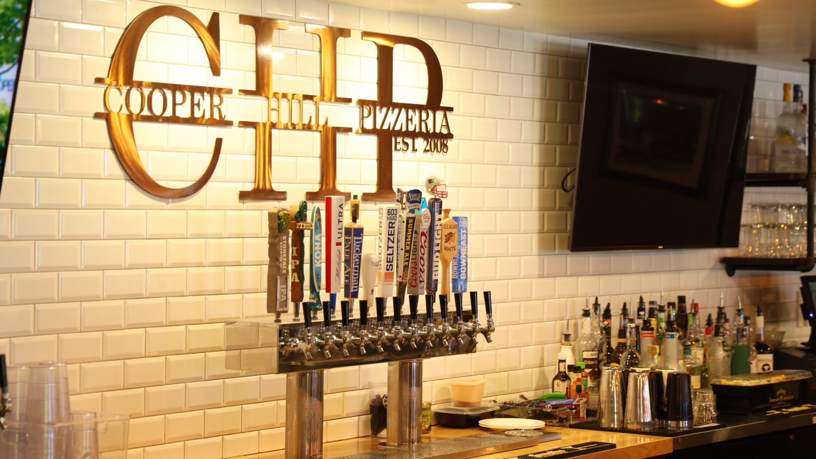 The draft taps under the gold Cooper Hill Pizzeria logo